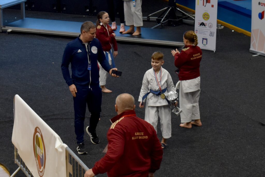 Teo Biškup, koji je još jednom osvojio naslov prvaka, s medaljom oko vrata i peharom, kraj njega je trener Dubovečak